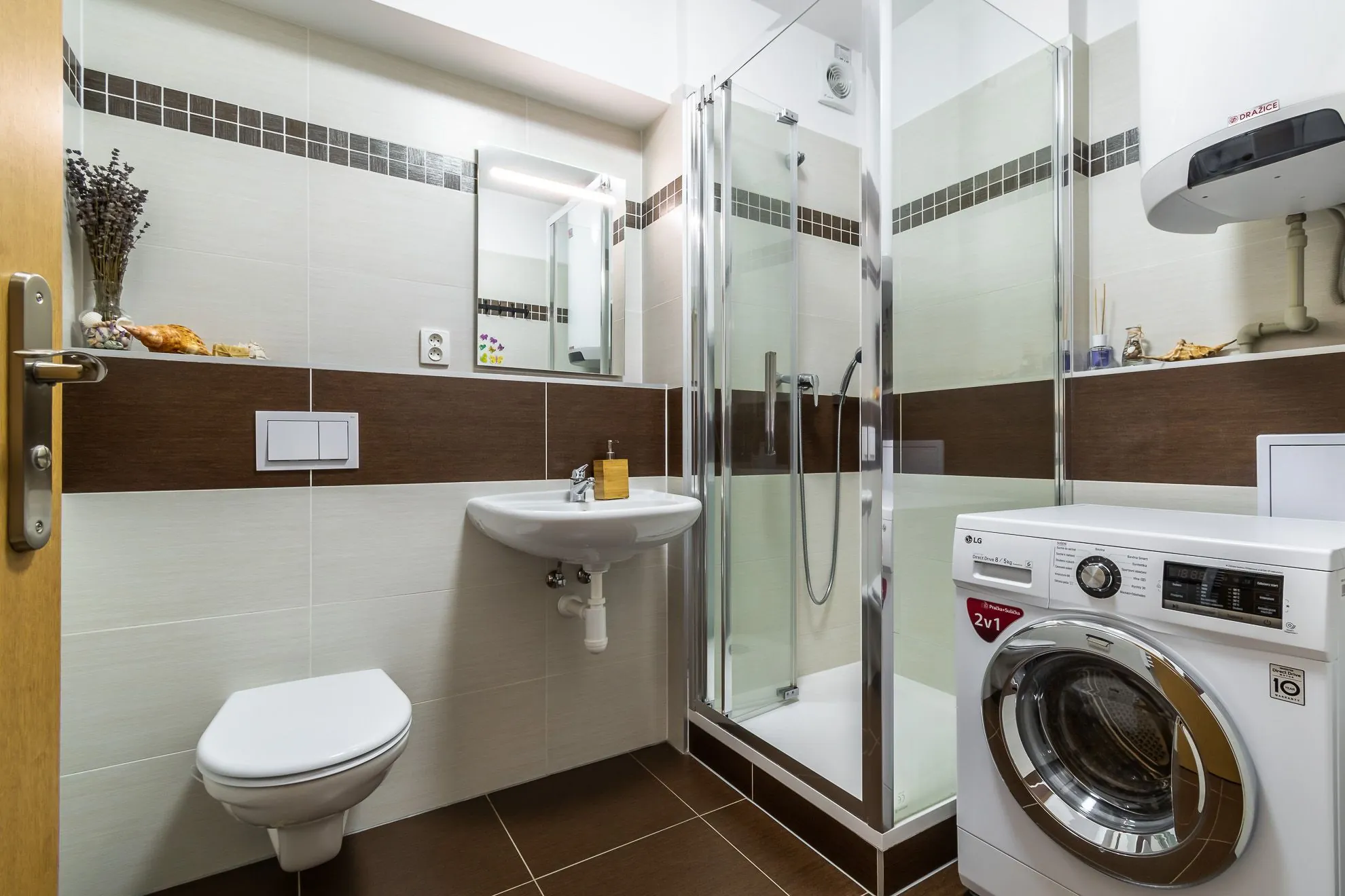 Koupelna s WC, sprchovým koutem a pračkou — byt 3+kk Jinočany